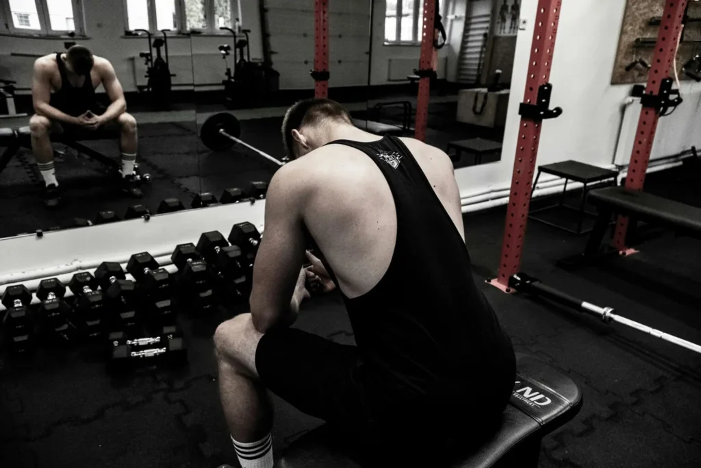 Praticante pensando na academia em como dividir os grupos musculares