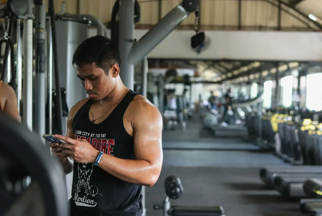 HOMEM MEXENDO NO CELULAR NA ACADEMIA
