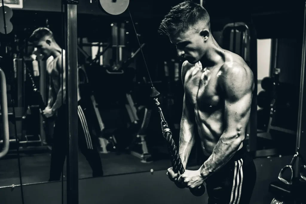 Homen fazendo triceps corda na academia