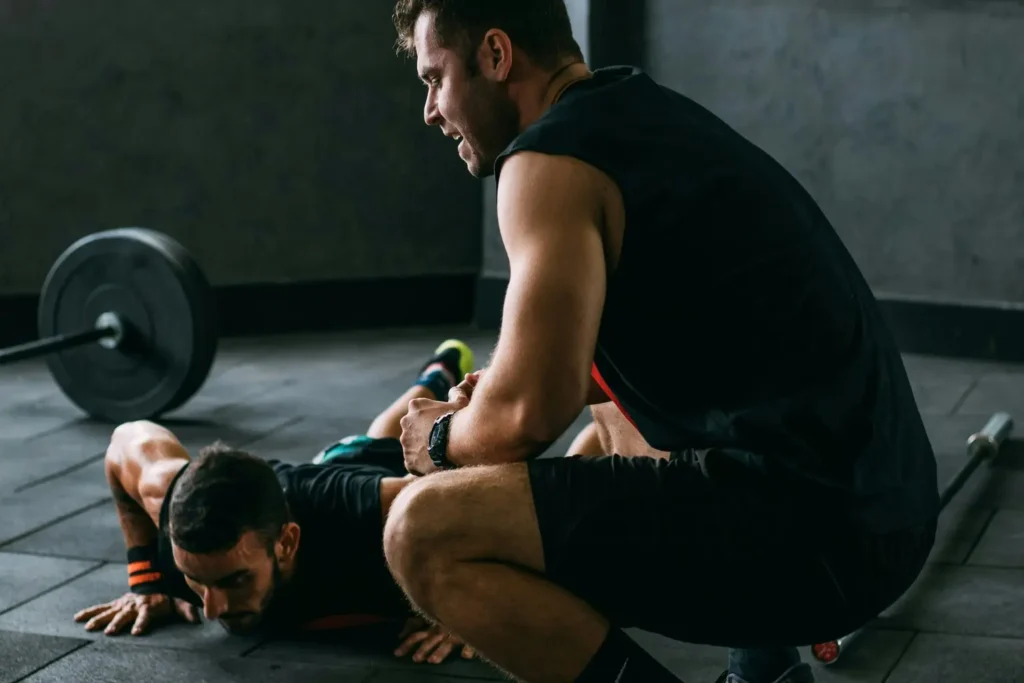 Homens se ajudando no treino ppl